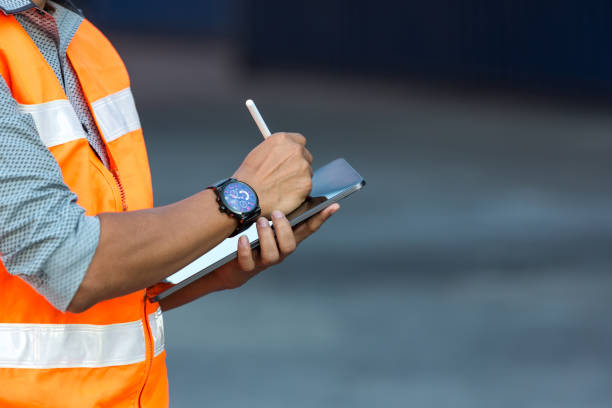 istock Foreman or worker hand holding tablet for writing and checking in goods in container at Container cargo site. 1359836364