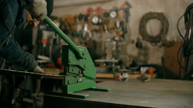 Locksmith uses guillotine mechanical sheet metal cutter at his workshop, manual metalwork, 4k Prores HQ