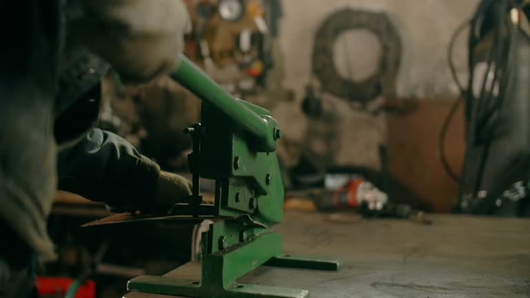 Locksmith uses guillotine mechanical sheet metal cutter at his workshop, manual metalwork, 4k Prores HQ