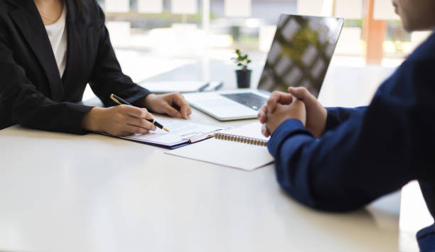 the manager is reading the resume and is interviewing the new employee. negotiating business and signing a contract. lawyer and legal advisor. - interview evenement stockfoto's en -beelden