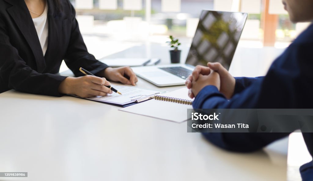 The manager is reading the resume and is interviewing the new employee. Negotiating business and signing a contract. Lawyer and legal advisor. Human Resources Stock Photo