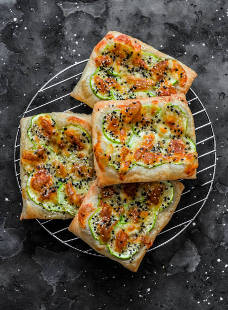 istock Mini pizza with zucchini, mozzarella and sesame on a dark background, top view. Delicious snack, snack, tapas 1359839702