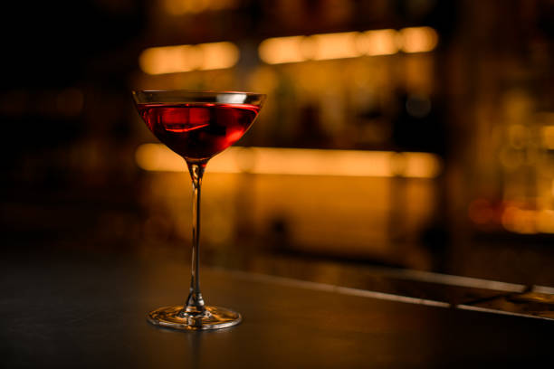 vista frontale di un bellissimo bicchiere sulla gamba lunga con bevanda rossa brillante sul tavolo - wine red red wine cocktail foto e immagini stock