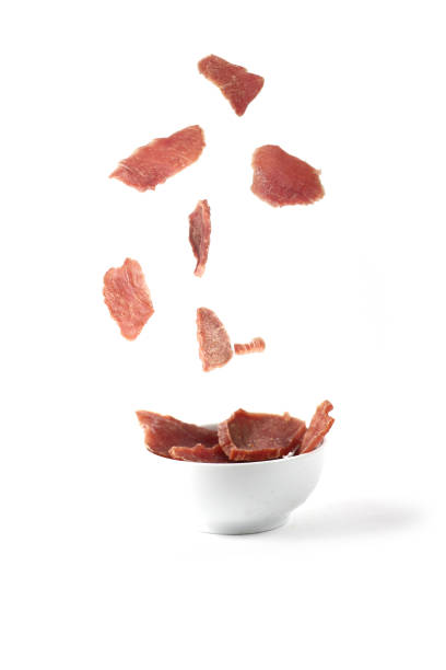 istock jerky meat pouring into a white bowl isolated against white background 1359841245