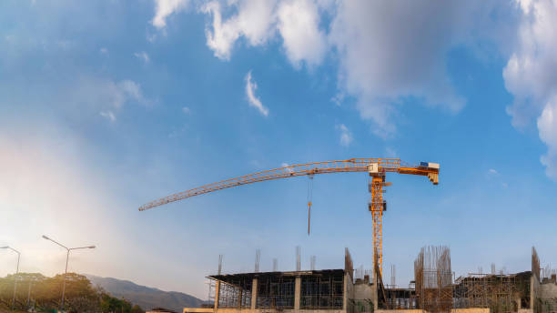 chantier avec grues sur fond de ciel et de soleil. - building contractor flash photos et images de collection