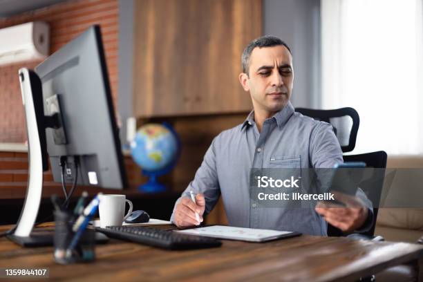 Tired Businessman In The Office Has Difficulty To See Texts On His Smartphone Concept For The Beginning Of Presbyopia Just After The Age Of 40 Years Stock Photo - Download Image Now