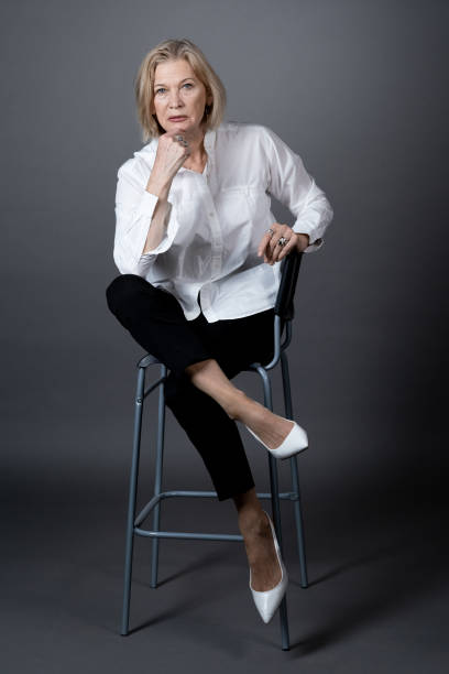 istock Mature woman in stylish clothes posing at camera 1359844201