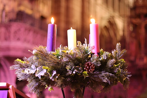 Lut advent candles on a wreath against a church background
