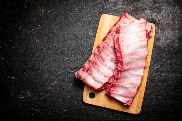 costillas crudas en una tabla de cortar. - delicatessen beef meat raw fotografías e imágenes de stock