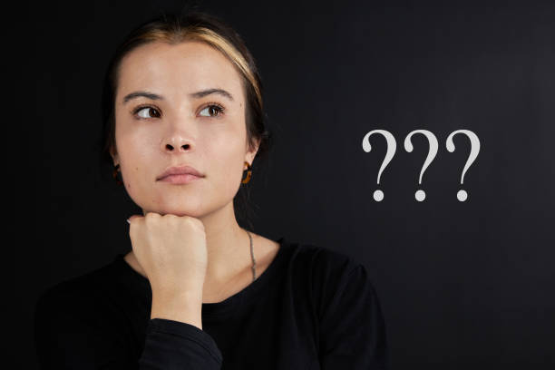 istock Portrait of a girl, brunette, in a brooding state against a dark background, question. 1359846091