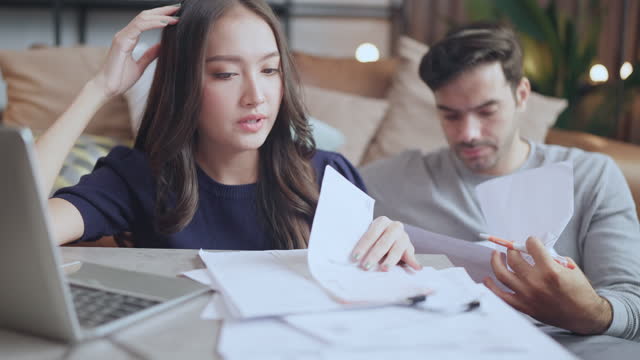 Unhappy spouses having financial problems Nervous family couple check paper mortgage loan credit payment notification, feeling stressed about termination , calculating monthly expenses debt.