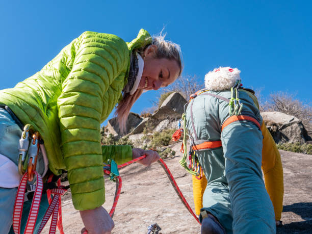 istock Mountain climber belays teammate on multi-pitch route 1359848344