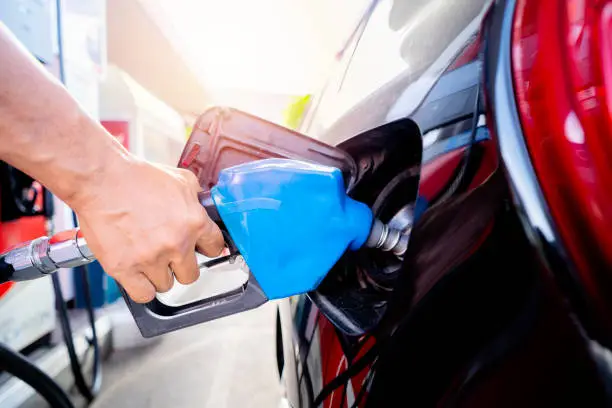 Photo of Refuel cars at the fuel pump. The driver hands, refuel and pump the car's gasoline with fuel at the petrol station. Car refueling at a gas station Gas station