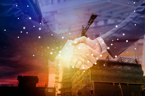 istock Two confident business man shaking hands during a meeting in the office, success, dealing, greeting and partner concept. Silhouette heavy industry 1359849818