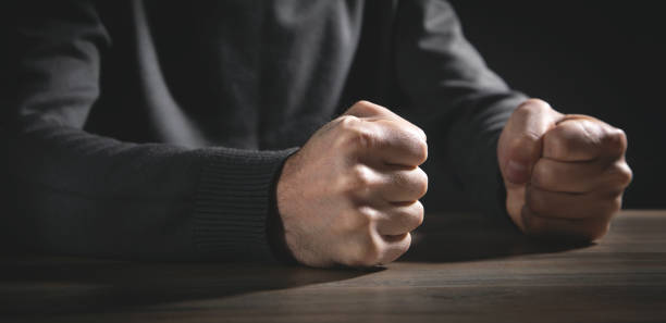 istock Fists of angry man beats on the table. 1359851379