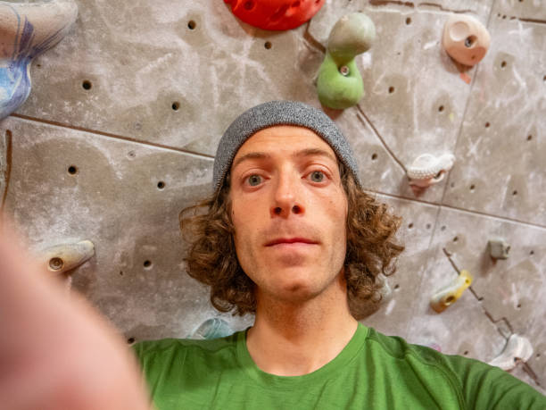 istock Young man bouldering in gym takes selfie 1359851777