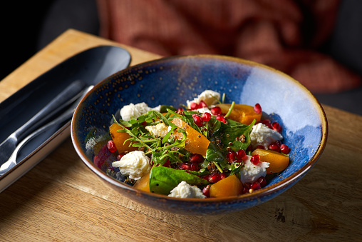 Delicious persimmon salad with pomegranate and arugula