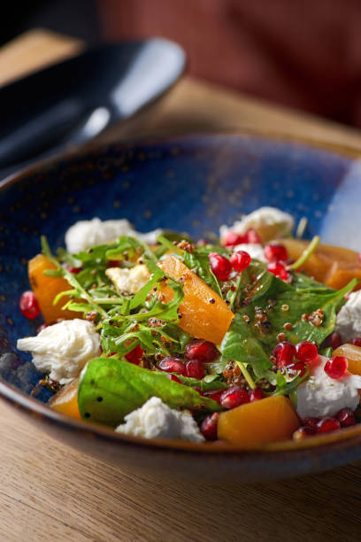 istock Delicious persimmon salad with pomegranate and arugula 1359853859
