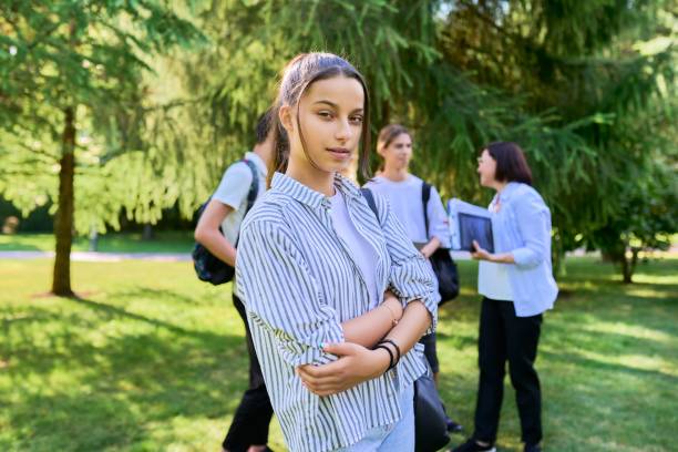 female student 14, 15 years old with textbooks backpack, in school park - teenager 14 15 years 13 14 years cheerful imagens e fotografias de stock