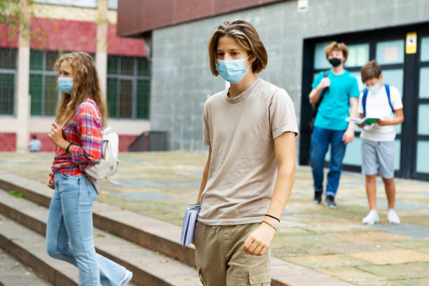 istock Boy in mask going to home after lessons 1359855272
