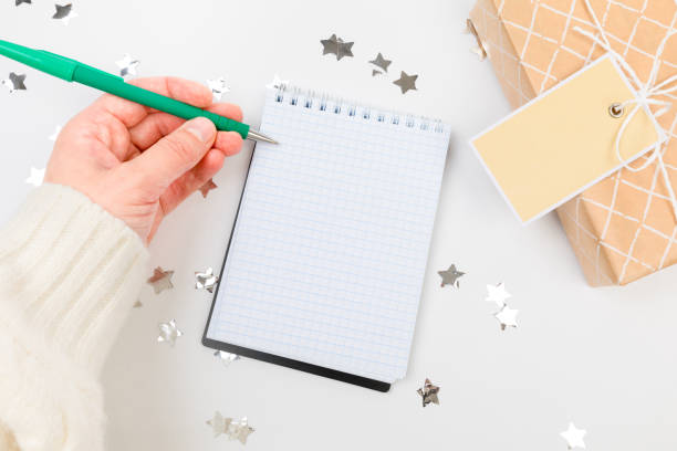 istock Festive decorations and notebook with wish list on white background , flat lay . Planning concept. 1359856335