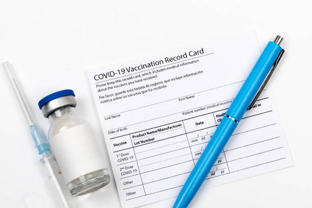 istock Covid-19 vaccine vial, vaccination record card, syringe, a pen  Coronavirus vaccination concept. 1359856400