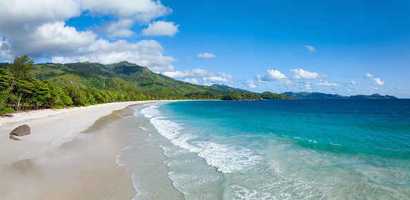 Beautiful Grand Anse Beach Panorama. Empty Beach on Mahé Island under blue summer skyscape. Grand Anse Beach, Mahé Island, Seychelles, East Africa