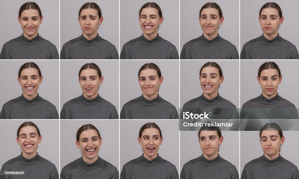 Young beautiful model girl standing in front of gray background in different poses. Portraits of young girl and different facial expressions. Expressions that consist of different emotions such as 32 teeth smiling, sad, pessimistic, joyful. The beautiful girl working at the agency has different gestures and facial expressions. Facial Expression Stock Photo
