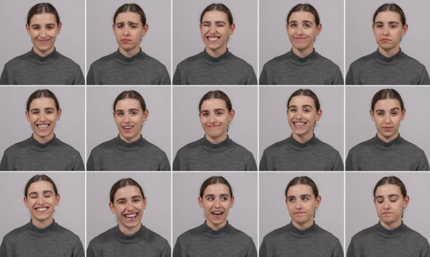 Young beautiful model girl standing in front of gray background in different poses. Portraits of young girl and different facial expressions. Expressions that consist of different emotions such as 32 teeth smiling, sad, pessimistic, joyful. The beautiful girl working at the agency has different gestures and facial expressions. facial expression stock pictures, royalty-free photos & images