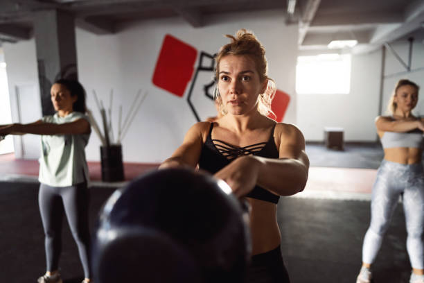 istock Dedicated fitness instructor, leading an exercise class in the modern gym 1359859001