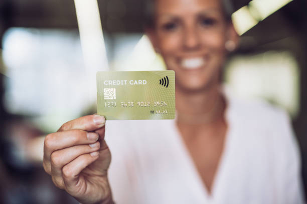 istock Woman holding a credit card. 1359859028