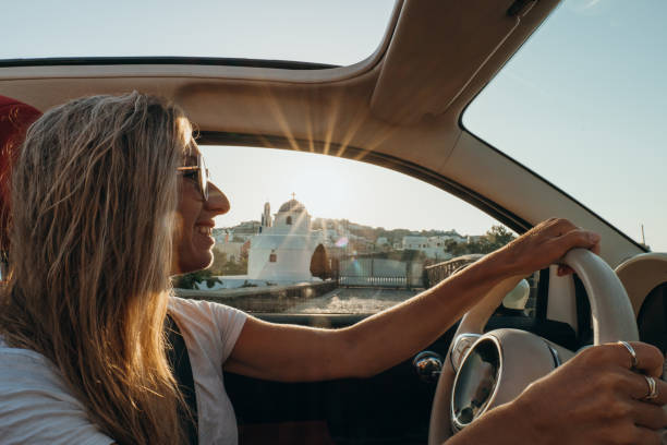 jeune femme conduisant une voiture au coucher du soleil, concept de road trip - car door flash photos et images de collection