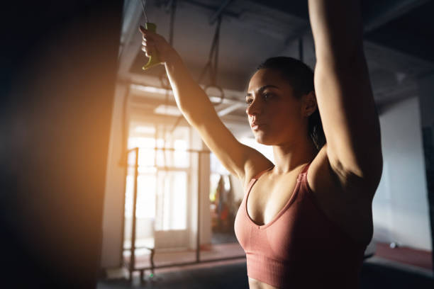 young Caucasian woman, exercise on a lat pulldown weight training ski machine, in the gym