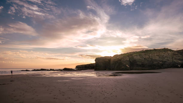 istock The sun goes down behind the cliffs of a beach 1359862697