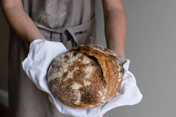 istock Hands holding a fresh sourdough bread 1359864187