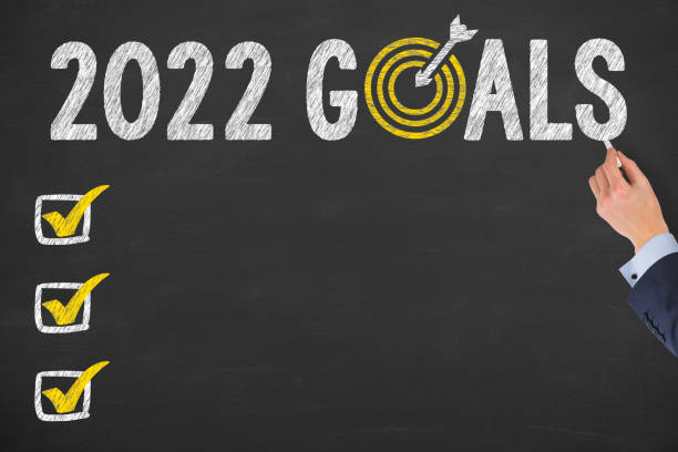 istock Human Hand Writing New Year 2022 Goals on Chalkboard Background 1359866142