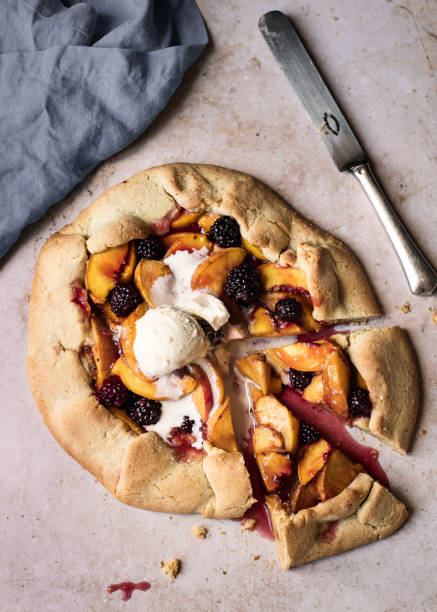 istock fruity peach pie with ice cream on a stoned underground with a knife and a cloth 1359866345