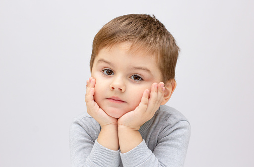 little boy crying with sad face in poverty on white background stock photo