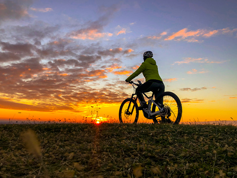Cyclist with ebike rests and looks the landscape