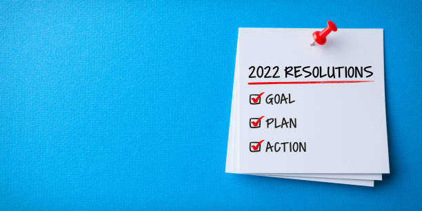 istock White Sticky Note With New Year 2022 Resolutions And Red Push Pin On Blue Background 1359866507