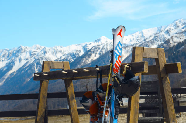 skis alpins, chaussures, casque, bâtons dans un rack sur fond de montagne - ski old wood pair photos et images de collection