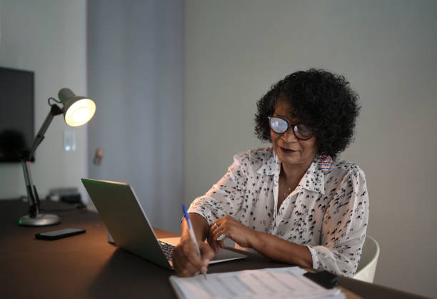 femme âgée utilisant une feuille de calcul de contrôle d’ordinateur portable à la maison - house quality control examining construction photos et images de collection
