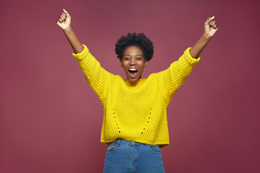 Happy exited african american woman champion rejoicing success, feeling euphoric with achievement, celebrating win, shouting, raising hands. High quality photo