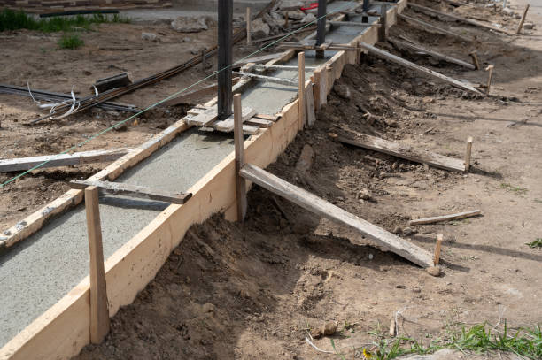 istock Pouring concrete into fence base at dacha 1359868572