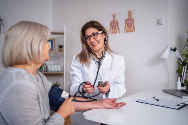 une femme adulte mature fait vérifier sa tension artérielle - primary care photos et images de collection