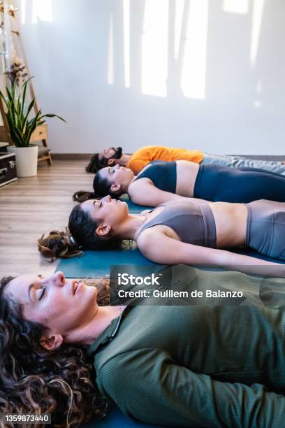 Group Meditating In Corpse Pose Stock Photo - Download Image Now - Lying Down, Indoors, Shavasana