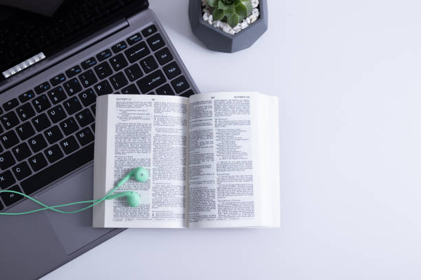 istock Open Bible and laptop on the work table with headphones. Bible Study Online 1359874737