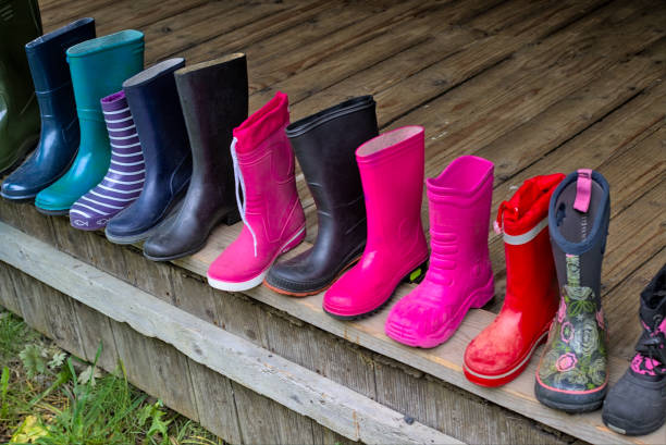 Colored rubber boots on a street market. Safety shoes in different styles and colors. Colorful products without a pair. Sale of rubber shoes in seasons.