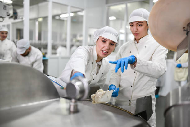 istock Two Female Stuffed Pepper Factory Workers Checking How Much Cheese There Is In Machine 1359881845