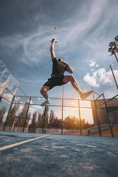 młody mężczyzna uderzający piłkę wiosłową. - tennis ball tennis racket tennis vertical zdjęcia i obrazy z banku zdjęć